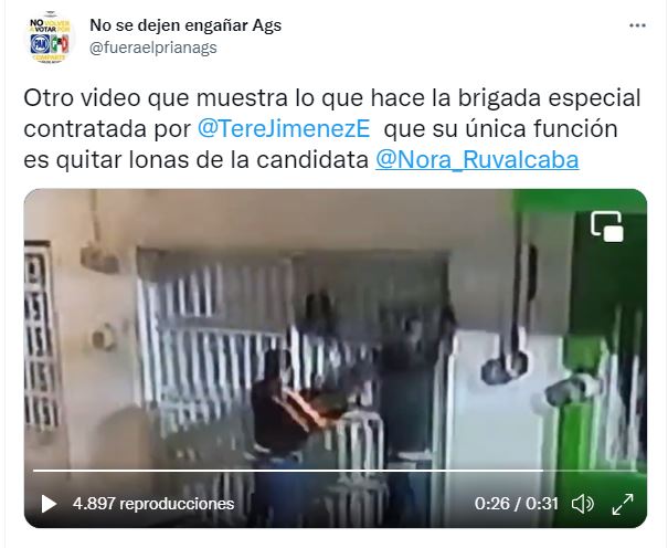 Dos hombres se acercan a la fachada de una casa en Aguascalientes para quitar las lonas de la candidata de Morena | Foto: Captura de pantalla 